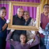 Ausby Family pose and hold golden frame