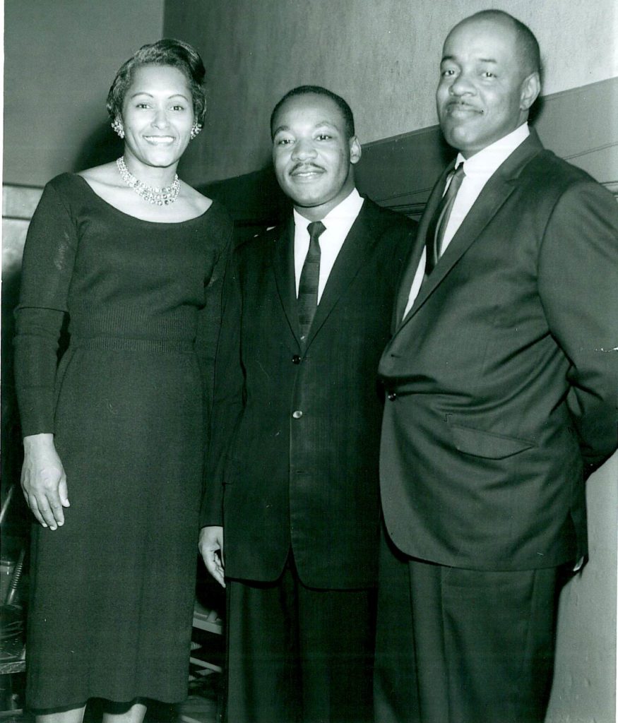 (l to r) Mrs. Doggett, Martin Luther King Jr and Rev Doggett stand close together at the Los Angeles freedom diner smiling for a photo