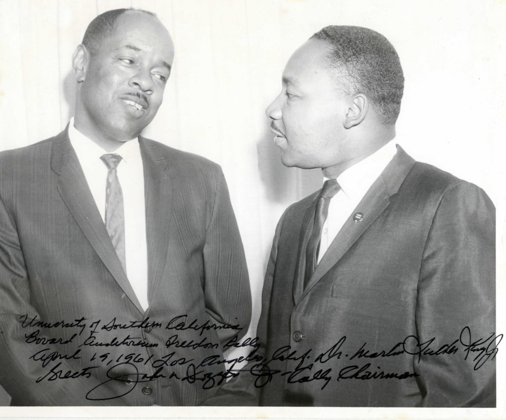 pictured are Rev Doggett listening intently as a very young Martin Luther King Junior stands profile next to him speaking
